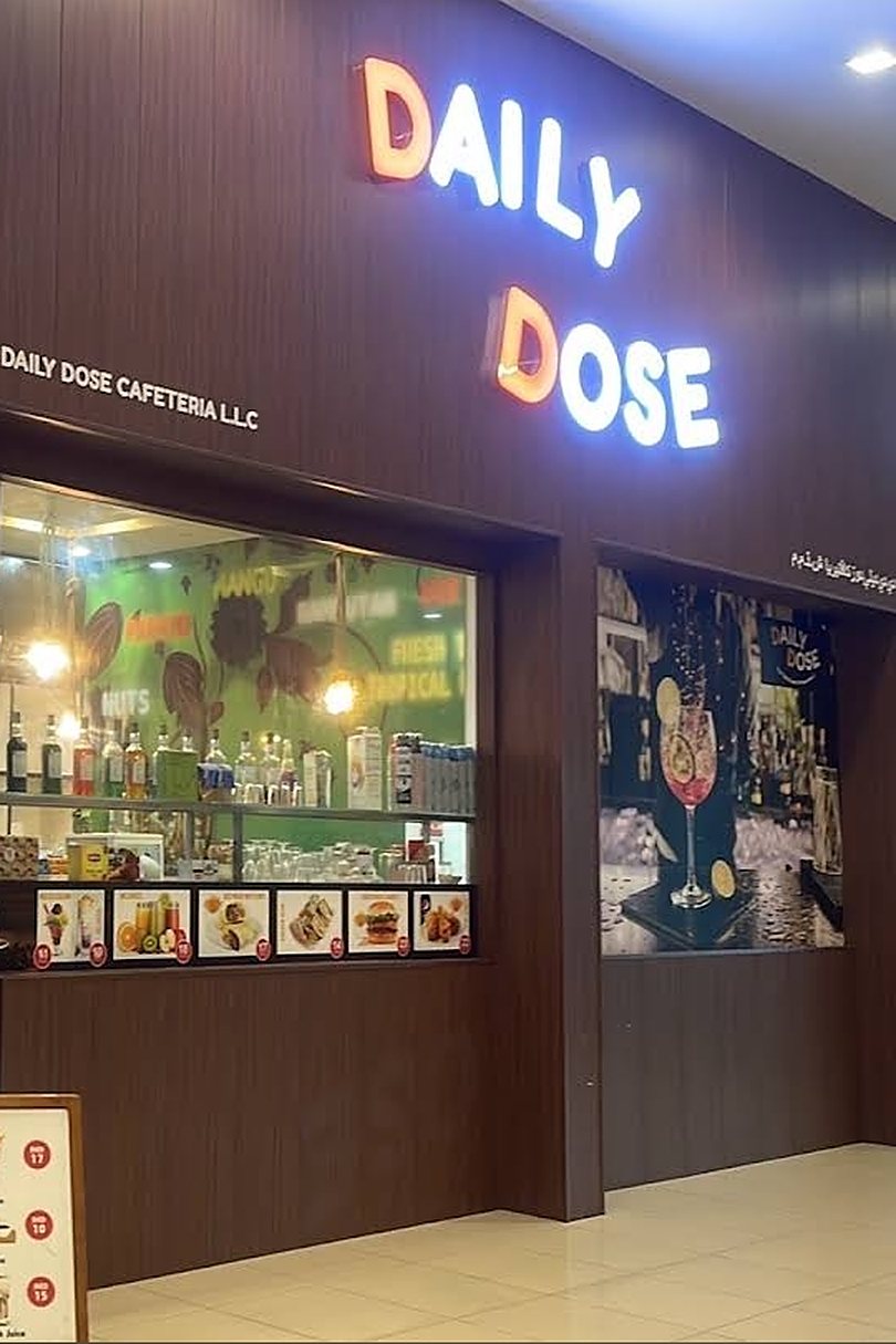 The glowing DAILY DOSE sign above the cafeteria's shopfront in Dragon Mart 2, Dubai